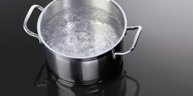 Um tacho com água a ferver numa placa de indução da AEG