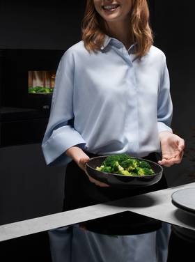 Mulher a cozinhar na placa