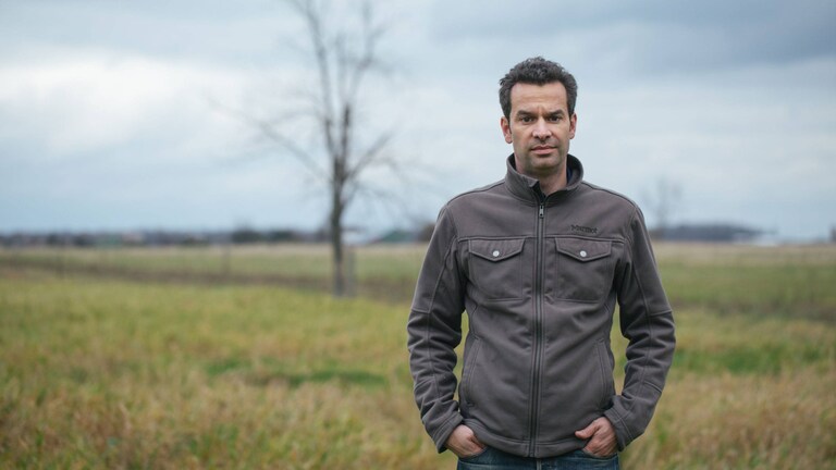 Mark Schatzker num campo com erva