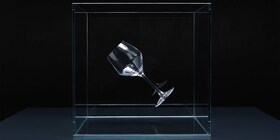 Um copo de vinho de cristal transparente suspenso num cubo